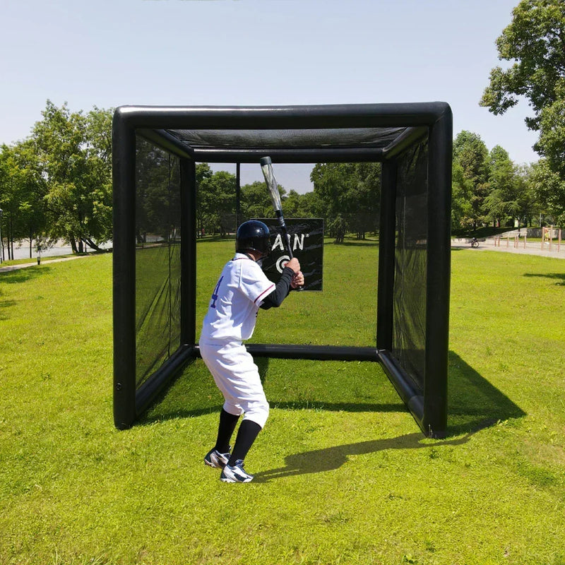 A baseball player in a white uniform and helmet taking a full swing inside a 10x10ft FunJain inflatable hitting station. The image demonstrates the 3D enclosed netting and black air-filled pillars during a backyard training session.